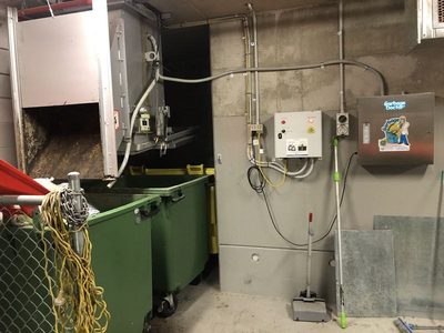 Garbage Doctor 3000 in a waste room beside the chute's controls, over green bins