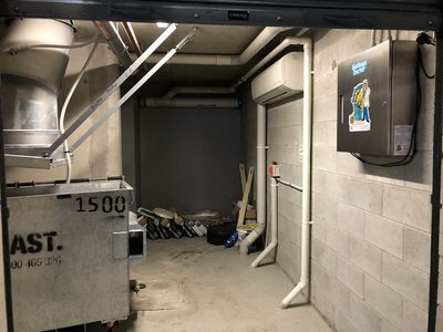 Garbage Doctor 3000 beside a 1500-litre galvanised bin under a garbage chute