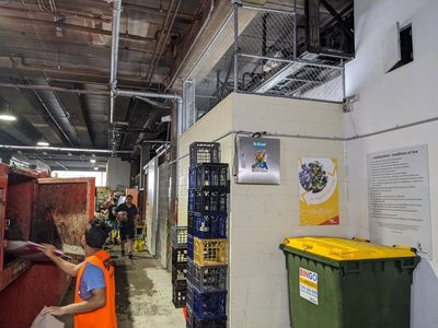 Garbage Doctor 3000 on the wall of a busy loading dock, beside a skip and a recycling bin