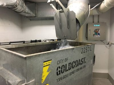 Garbage Doctor 3000 beside a chute over a 2250-litre galvanised refuse bin