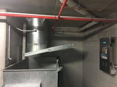 Garbage Doctor 4000 beside a galvanised chute and its hopper door over a refuse bin