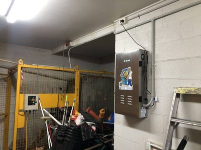 Garbage Doctor 4000 on a block wall in a waste store, beside a yellow cage