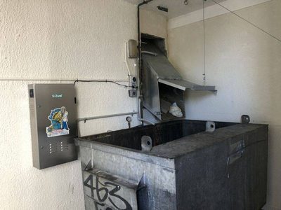 Garbage Doctor 4000 beside a chute's hopper over a galvanised rubbish bin
