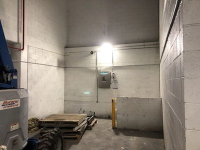 Garbage Doctor 5000 on the far wall of a waste store with pallets and a forklift