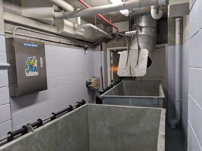 Garbage Doctor 5000 beside a chute discharge over two galvanised refuse bins
