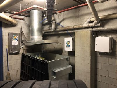 Garbage Doctor Scenting's control unit and scent tank either side of a round garbage chute