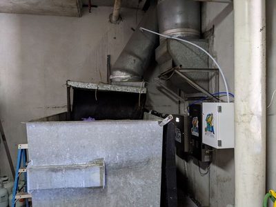 Garbage Doctor Scenting beside an angled garbage chute over a galvanised refuse bin