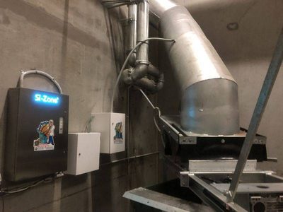 Garbage Doctor Scenting with a Si-Zone ozone unit beside a large angled waste chute