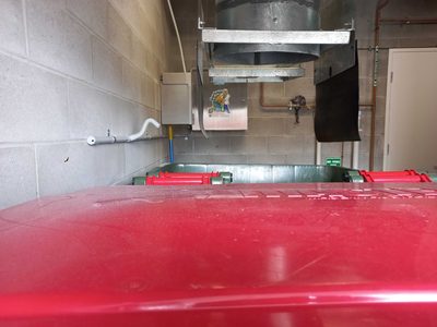 Garbage Doctor Duo beside a round garbage chute over a bin with a red lid