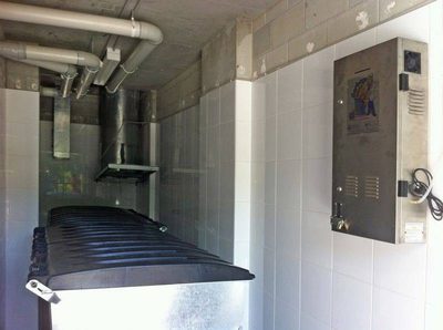 Garbage Doctor Platinum on a tiled wall beside a garbage chute, over a black-lidded bin