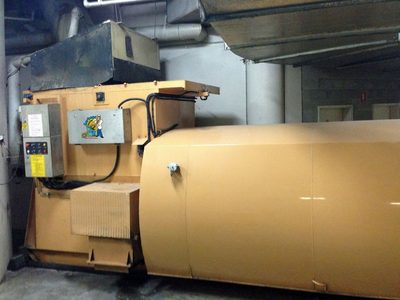 Garbage Doctor on the front of a large waste compactor at a loading dock, beside the compactor's controls