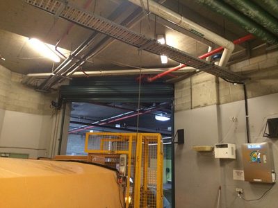 Garbage Doctor on the wall of a loading dock, beside a waste compactor and a roller door