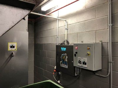 A Garbage Doctor 3000 beside a garbage chute and green bins