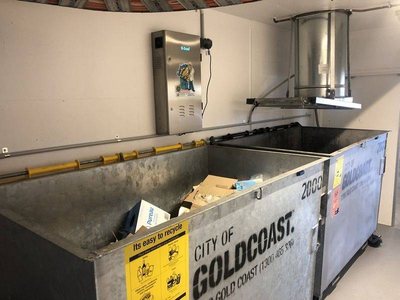 A Garbage Doctor 4000 above two large bins, beside the chute