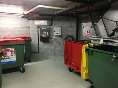 A Garbage Doctor Si-Zone 5000 in a bin room with red, yellow and green bins