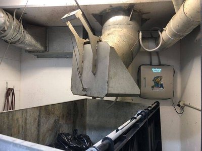 A Garbage Doctor Ozone beside a garbage chute's hopper
